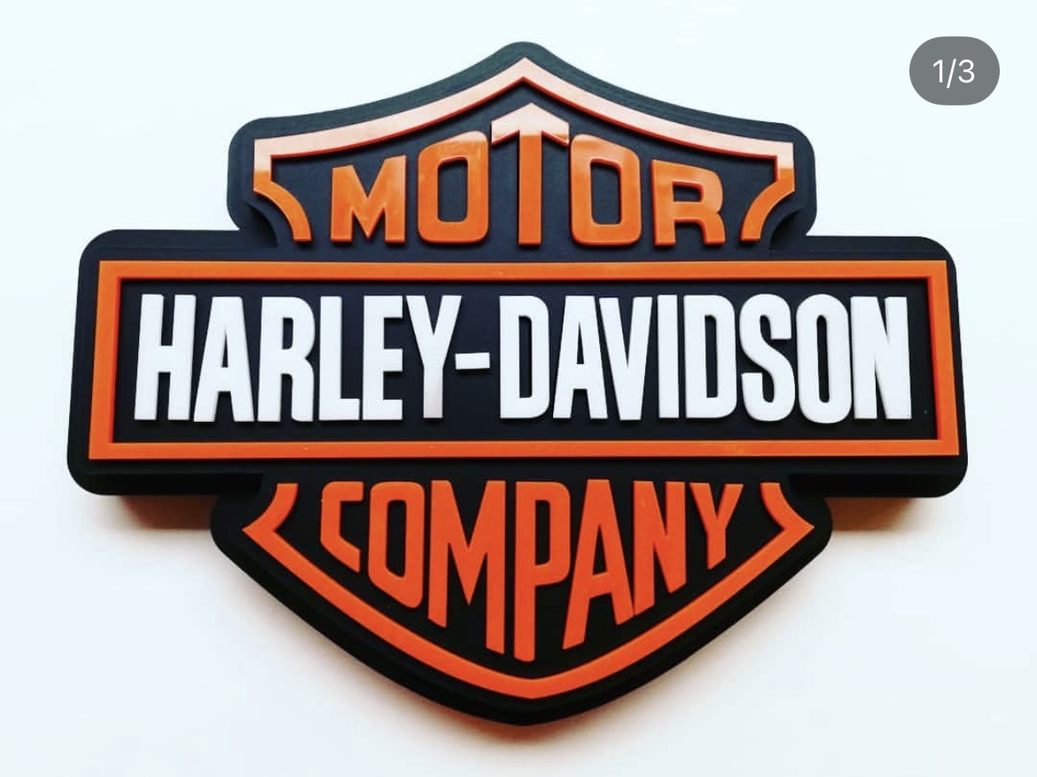 Emblema corpóreo Harley-Davidson en acrílico negro, naranja y blanco visto de frente